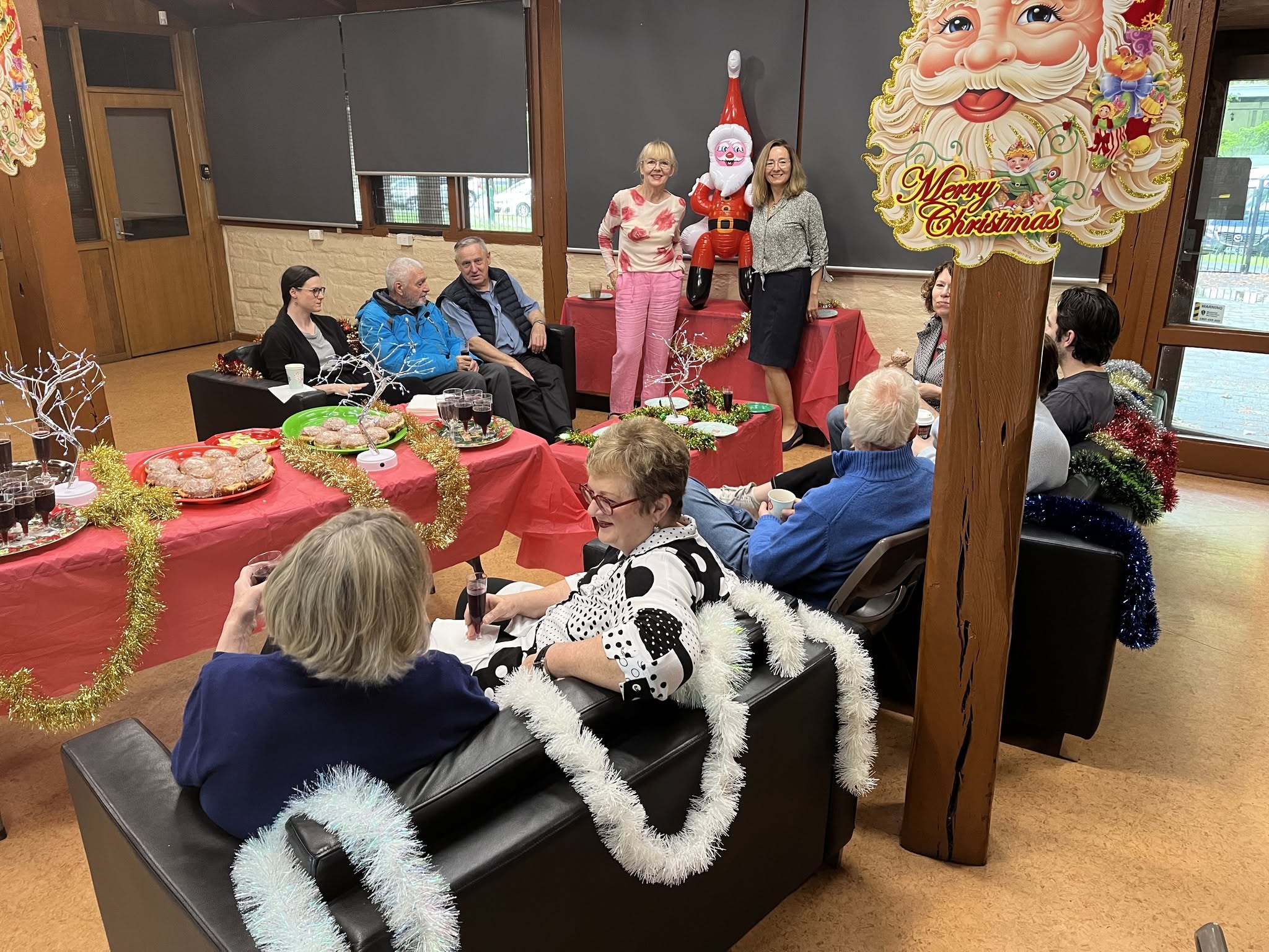 Adults gathered around decorated tables at a Christmas event.