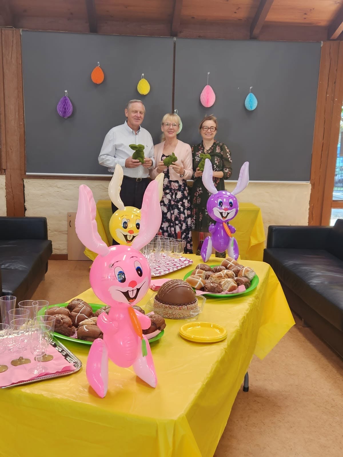 Adults gathered around decorated tables at an Easter celebration.